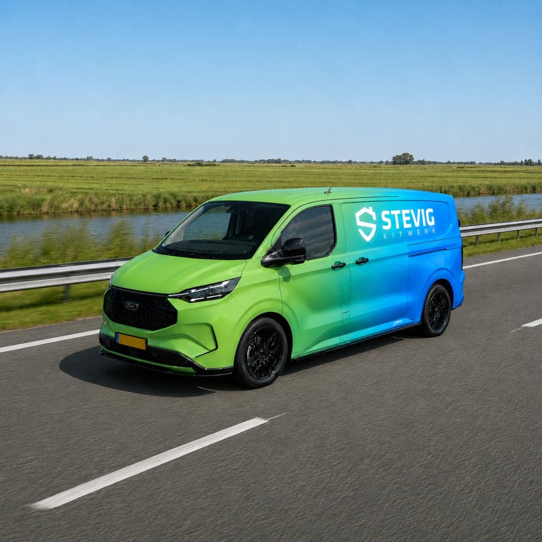 Bestelbus van Stevig Kitwerk met belettering in het groen-blauwe merkverloop, rijdend over een provinciale weg langs een sloot en weiland.